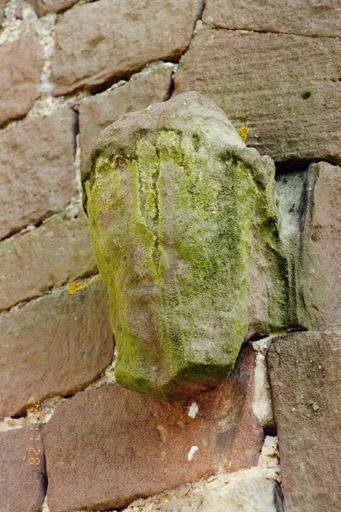 Tour, face nord, porte, tête sculptée à gauche du tympan.