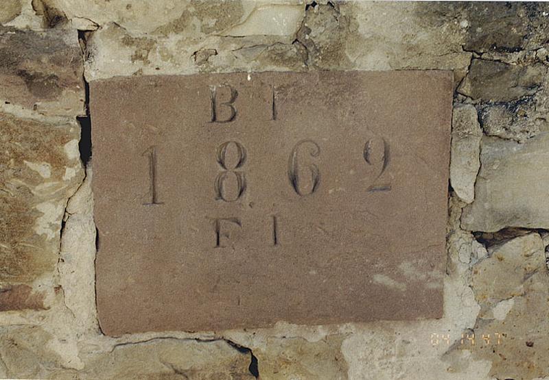 Vue de la table millésimée encastrée dans le mur du cimetière.