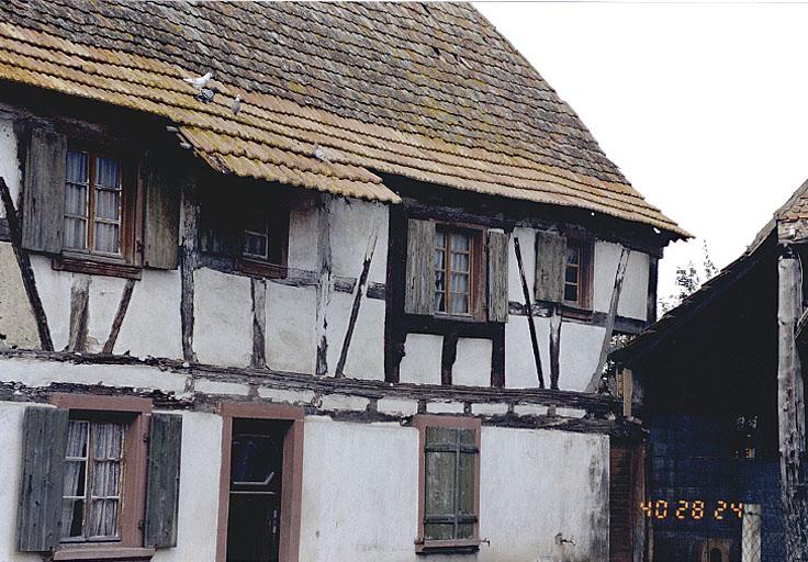 Vue de détail du pan de bois et de la baie à chambranle saillant.