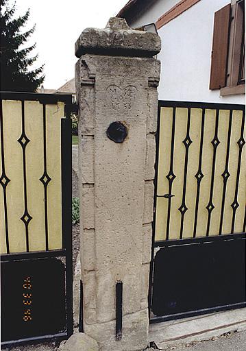 Vue du piédroit de porte piétonne et charretière de la ferme, No 32, rue Principale.