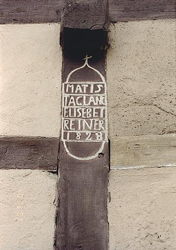 Vue du poteau cornier et de l'inscription de la ferme, No 21, rue Principale.