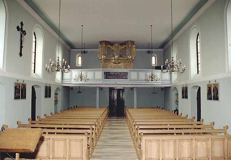 Vue intérieure de la nef vers la tour-porche, prise depuis le choeur.