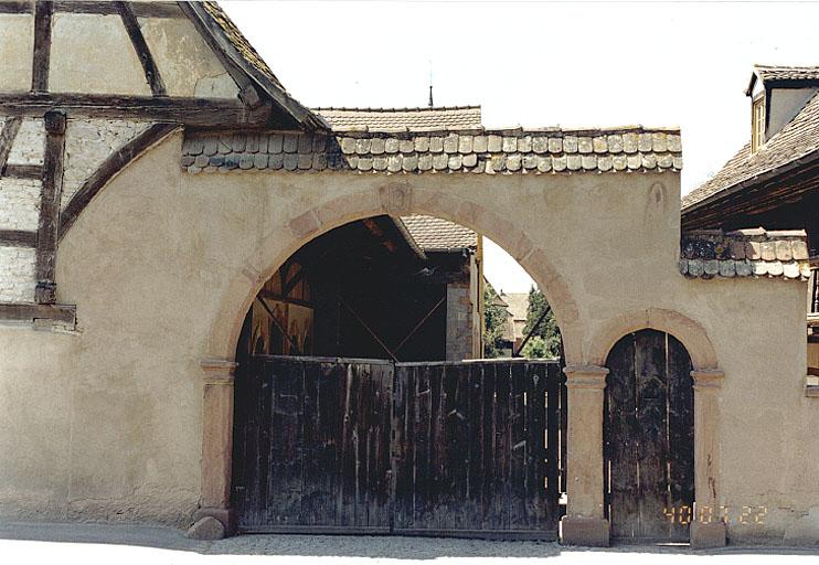 Vue du mur de clôture sur rue, du portail charretier et de la porte piétonne.