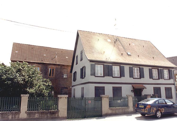 Vue des façades sur rue du logis et de l'usine, prise depuis le nord-est.