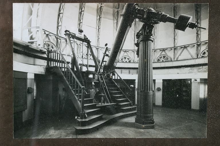 Tableau comportant 14 photos en noir et blanc relatives à l'histoire de l'Observatoire, vue de détail : la lunette équatoriale de Merz-Repsold avec à l'arrière-plan son escalier mobile.