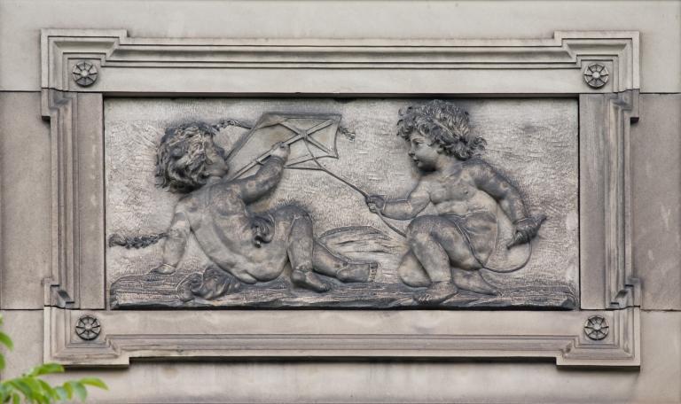 Vue du décor ornant le côté gauche du fronton de l'aile est, sur la façade sud : allégorie de la maîtrise des éléments de la nature par la physique - l'air (avec le cerf-volant).