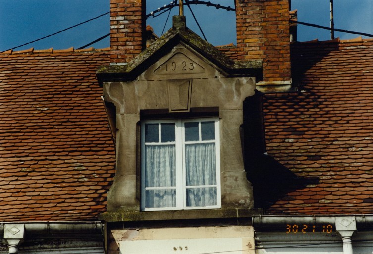 Lucarne passante sur la façade sur rue, portant la date 1923.