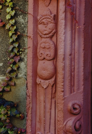 Porte du gouttereau ouest : détail du piédroit avec un décor sculpté représentant un animal (chatte ?) anthropomorphe.