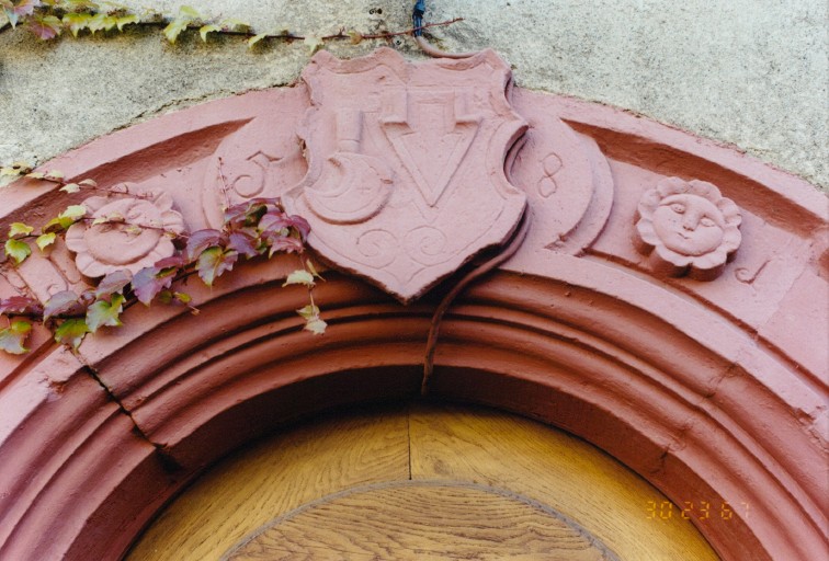 Porte du gouttereau ouest : claveau central avec date et armoiries de vigneron.