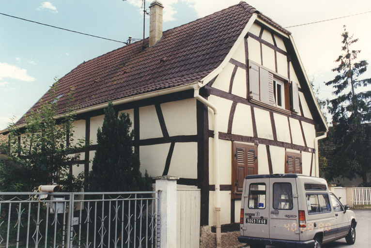 Maison : poteaux corniers à bois longs. Vue de trois quarts gauche.
