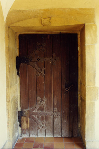 Vue de la porte latérale. Un remploi de l'ancienne église : chambranle et linteau sculpté aux armoiries des Wurtemberg.