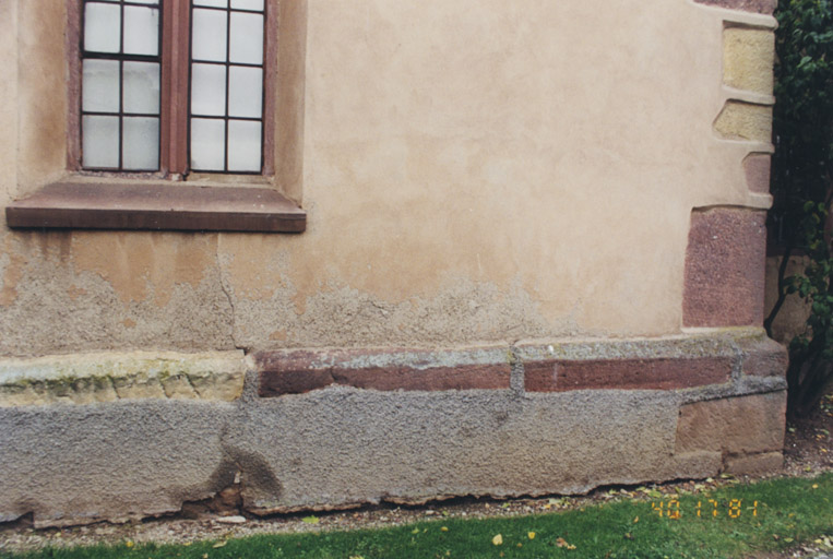 Vue de la façade est. Le solin de la tour et l'inscription remployée.