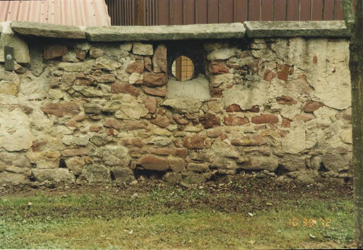 Détail du mur d'enceinte sud avec ancienne canonnière (?), en remploi (?).