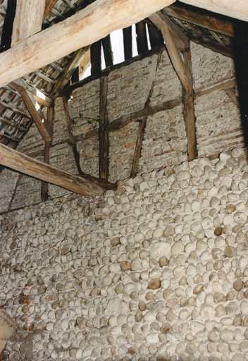 Pignon intérieur du hangar avec différents appareils en galets. Vue de détail.