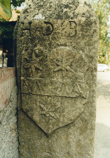 Détail d'un pilier de la cour avec blason et initiales HDB. Vue de détail.