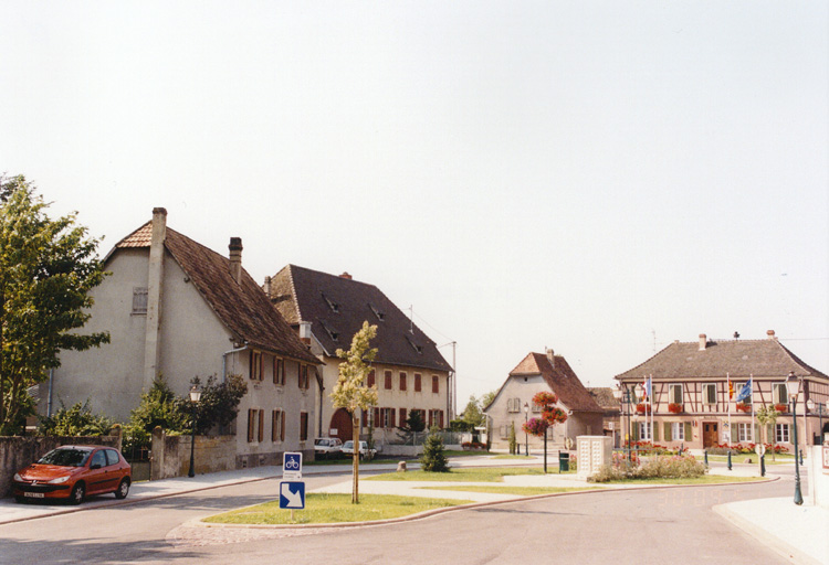 Vue générale de la place de l'Eglise depuis le nord ; ferme 1 place de l'Eglise ; ferme 28 rue Principale ; mairie-école 37 et 39 rue Principale.