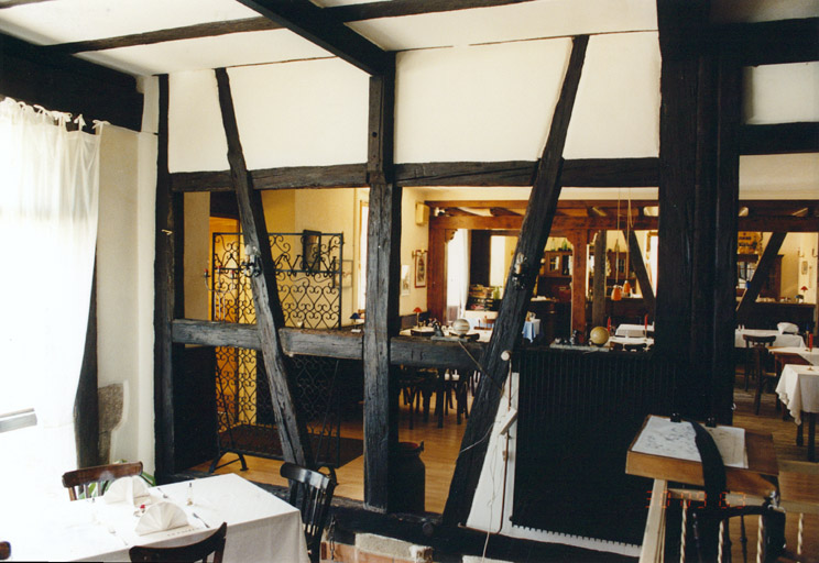 Vue de l'intérieur du restaurant (côté porte cochère) avec une cloison en pan de bois.