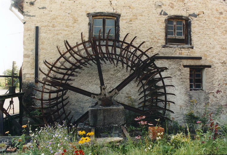 Vue d'ensemble du pignon Est avec fenêtres en arc segmentaire et roue à aubes, depuis l'ouest.