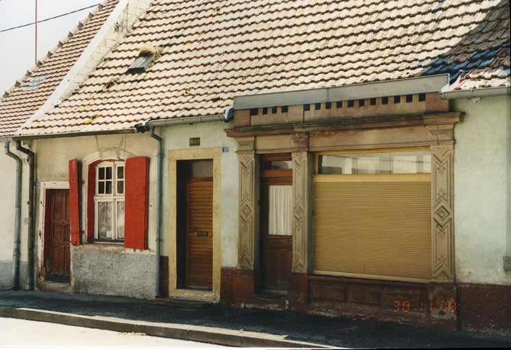 Vue d'ensemble depuis l'ouest; magasin et maison avec fenêtre en arc segmentaire.