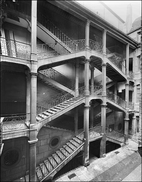 Vue d'ensemble de l'escalier à cage ouverte depuis le fond de la cour.