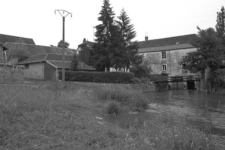 Vue des bâtiments depuis la dérivation de l'Ognon.