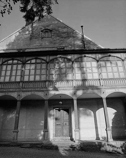 Galerie fermée sur colonnade flanquant la façade latérale.