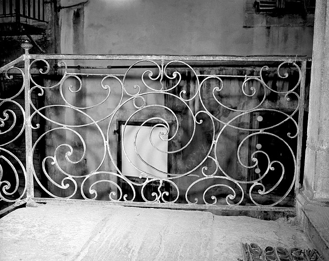 Escalier intérieur à cage ouverte sur la cour. Détail de la rampe.