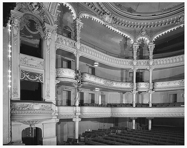 Salle, vue depuis la scène, sur l'avant-scène et les balcons de la salle.