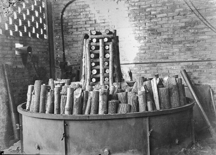 Fabrication de charbon de bois (ou de gaz carbonique ?) : 2e étape du chargement du bois dans la machine.
