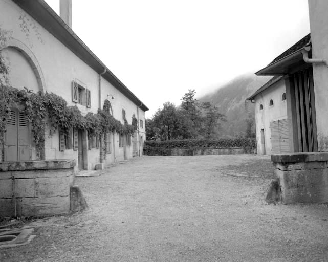 Vue des bâtiments situés de part et d'autre de la cour des communs.