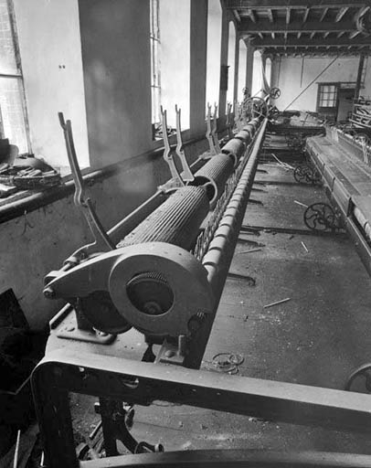 Ratelier du module de gauche.De gauche à droite, supports des cannelles, tambours cannelés et cylindres presseurs (surmontant les cylindres alimentaires non visibles).