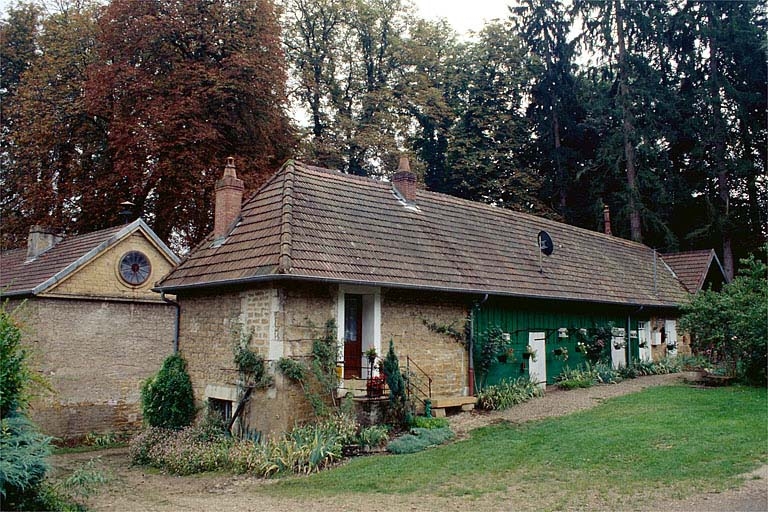 Logement d'ouvriers (M). Au second plan, à gauche : pignon de l'atelier de fabrication portant le cadran d'horloge de l'usine.