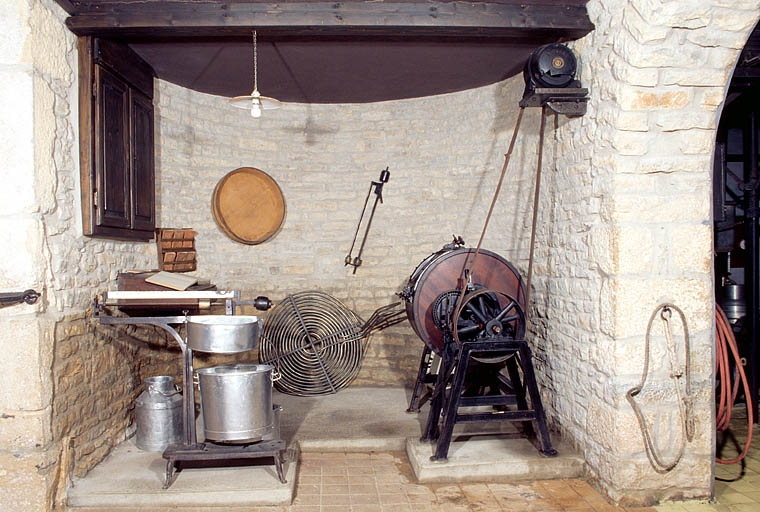Pièce d'exposition. Au premier plan : pèse-lait et baratte.