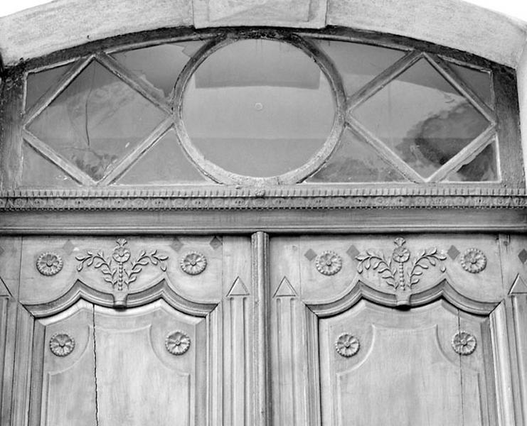 Façade antérieure : partie supérieure de la porte principale et imposte.