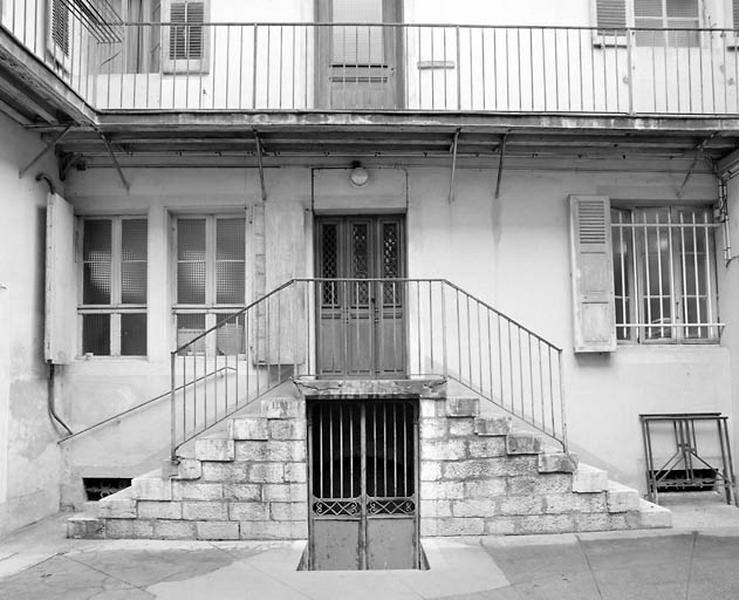 Façade postérieure : rez-de-chaussée surélevé et escalier extérieur.