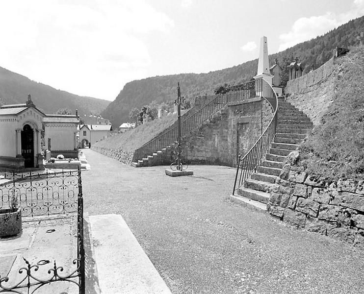 Centre du cimetière, avec croix et mur en hémicycle.