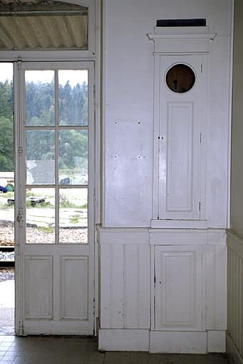 Bâtiment des voyageurs : caisse d'horloge comtoise encastrée dans le mur de la salle d'attente.