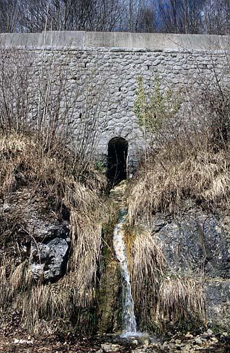 Vue d'ensemble. Aqueduc (au PK 053.061) ouvert dans un mur de soutènement.