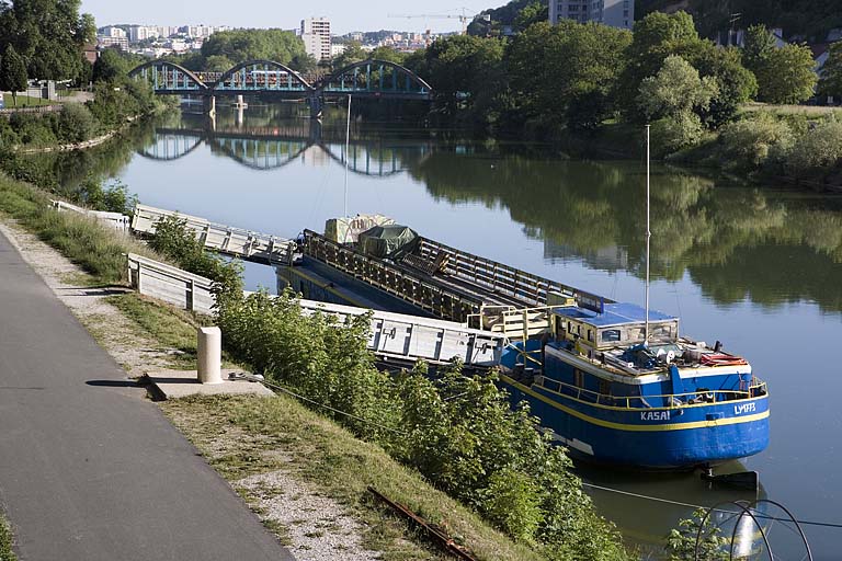 Péniche amarrée dans la partie sud du port de Rivotte, avec le pont de Chardonnet en arrière-plan.