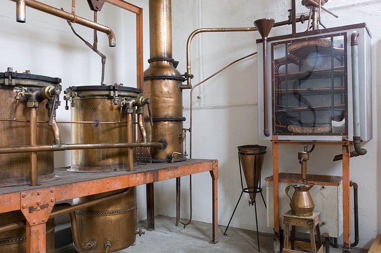 Salle de distillation. Alambics, colonne de rectification et réfrigérant.