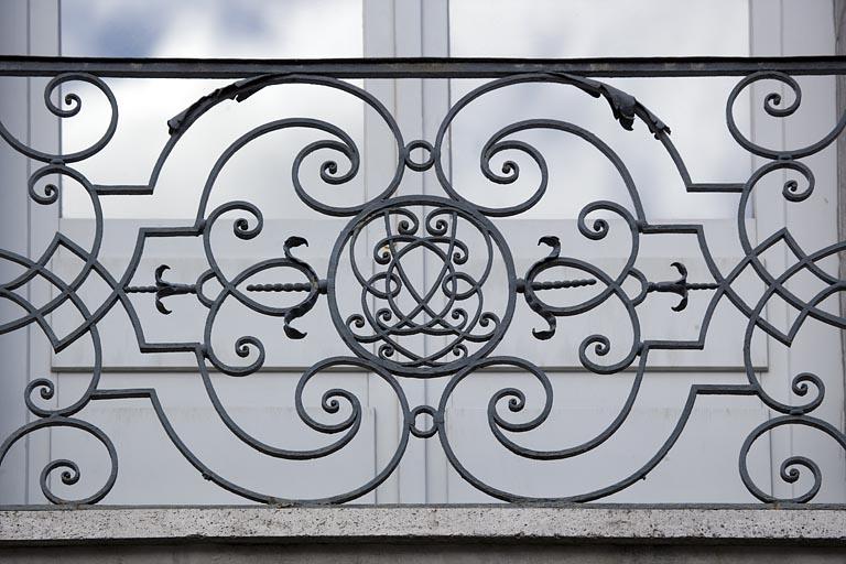 Façade sur rue : détail de la partie centrale de la ferronnerie du balcon.