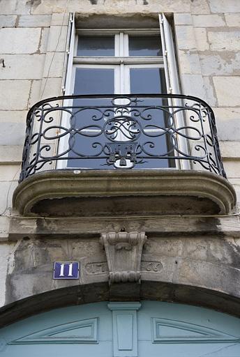 Détail du balcon en fer forgé sur rue avec la porte-fenêtre.