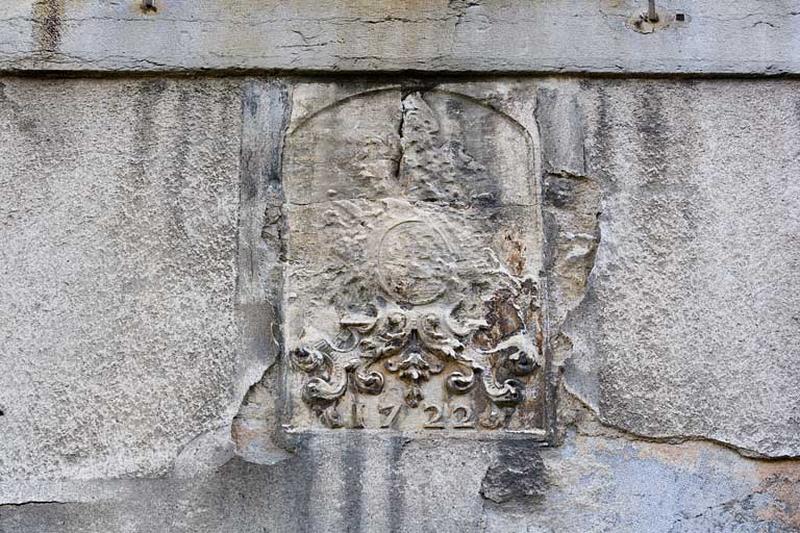 Détail d'un blason bûché daté 1722 sur une baie du rez-de-chaussée.