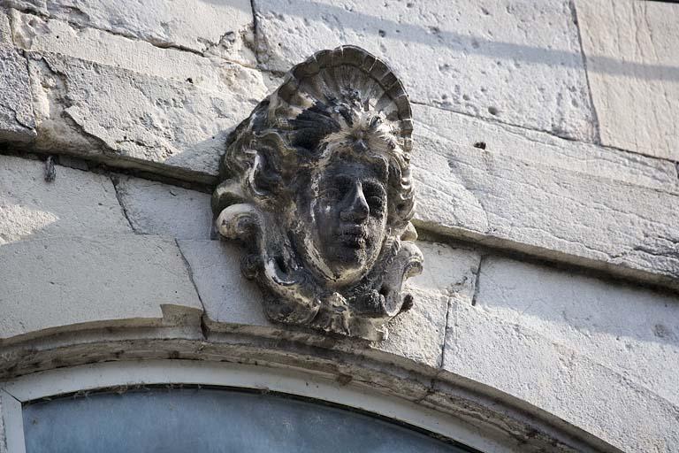 Détail de la clé d'une fenêtre au premier étage sur rue : figure coiffée d'une coquille.