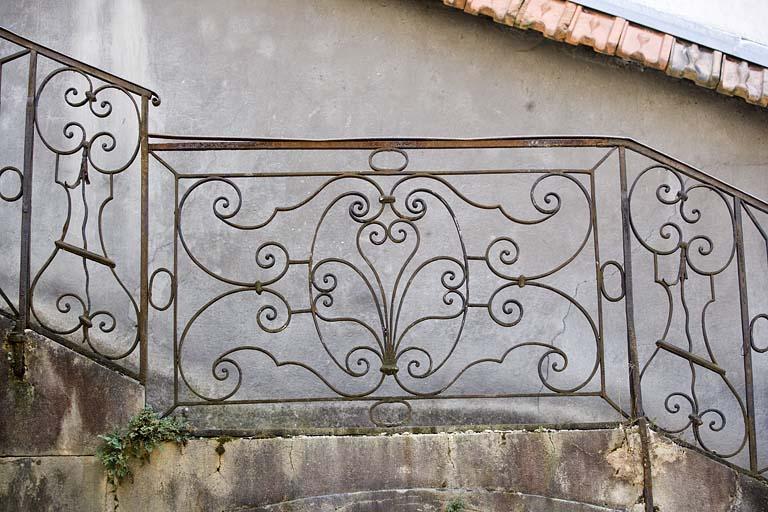 Détail de la rampe en fer forgé de l'escalier isolé dans la deuxième cour.