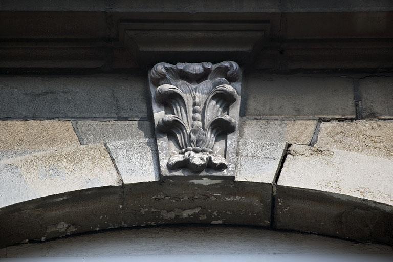 Détail d'une clé sur une fenêtre du deuxième étage sur rue.