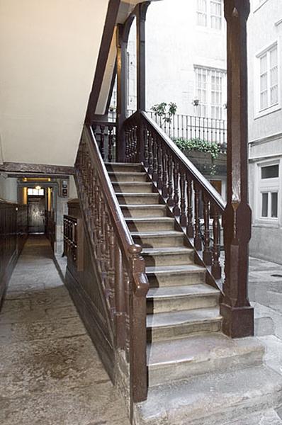 Vue du départ de l'escalier à cage ouverte depuis le couloir.