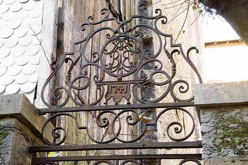 Détail de la partie supérieure de la porte en fer forgé conduisant au jardin.