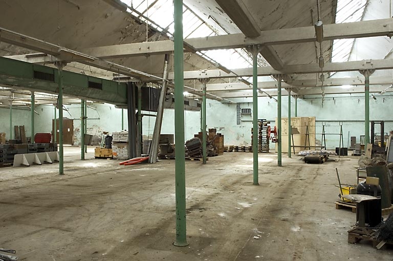 Atelier de fabrication de l'ancienne filature. Travées délimitées par des colonnes de fonte et couvertes de sheds.