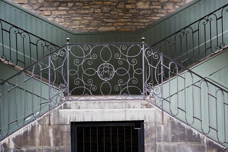 Escalier à cage ouverte à droite de la première cour : détail de la grille en ferronnerie.